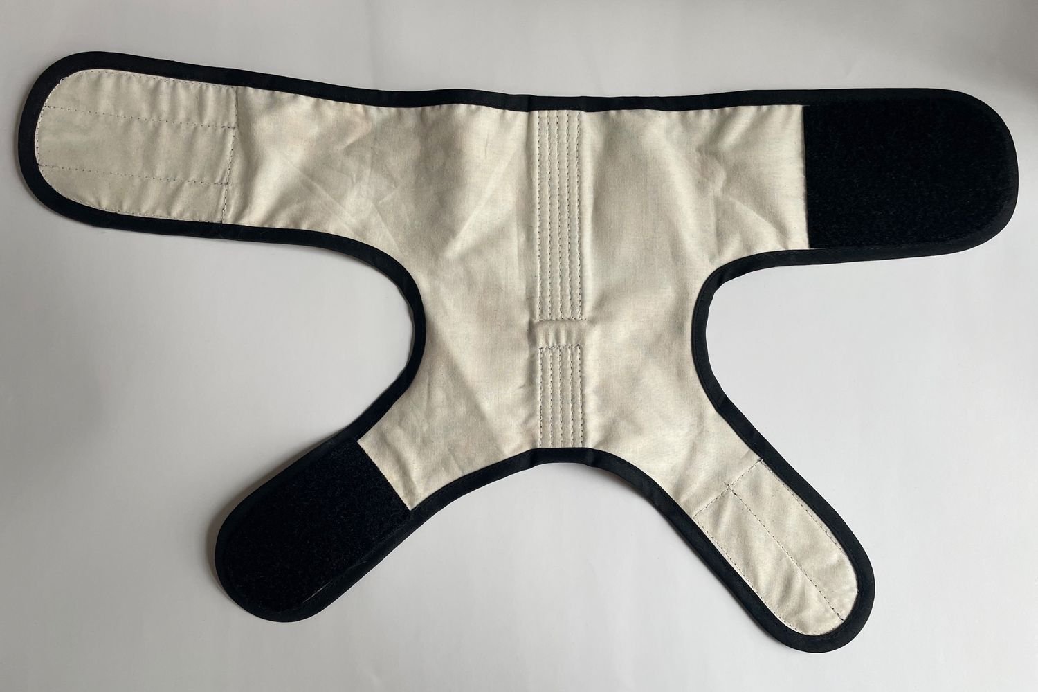 The inside of the Kitty Holster Cat Harness on a white background