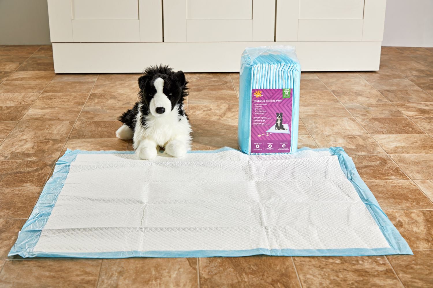 IMMCute Puppy Pee Pad displayed on a laminate floor in front of a box of an unopened box of pee pads and a stuffed dog